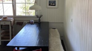 A kitchen with a long table, a red chair, a white bench, and a framed picture on the wall. - mit Bergblick by Interhome (Rueras Dieni)