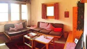 Una sala de estar acogedora con un sofá, una mesa de centro y un televisor.