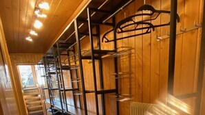 A kitchen with wooden cabinets, metal shelving, and a built-in oven.