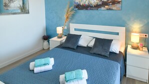 A bedroom with a bed, two bedside tables, a nightstand, a lamp, a vase with flowers, and a painting on the wall. - mit privatem Parkplatz by Interhome (Gradac)