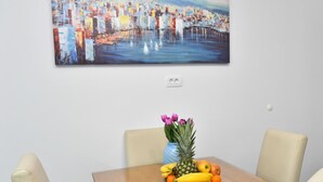 A dining table with a fruit bowl, a vase with flowers, and a painting on the wall. - mit privatem Parkplatz by Interhome (Gradac)