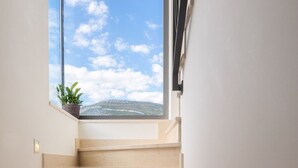 Una escalera con vistas al cielo y una planta en la barandilla.