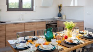 Una cocina moderna con una mesa de desayuno servida, mostrando una variedad de platos y bebidas.