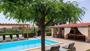 A swimming pool with lounge chairs and a covered dining area. - Angenehmes Haus in Posedarje mit großem Garten by Interhome (Posedarje)