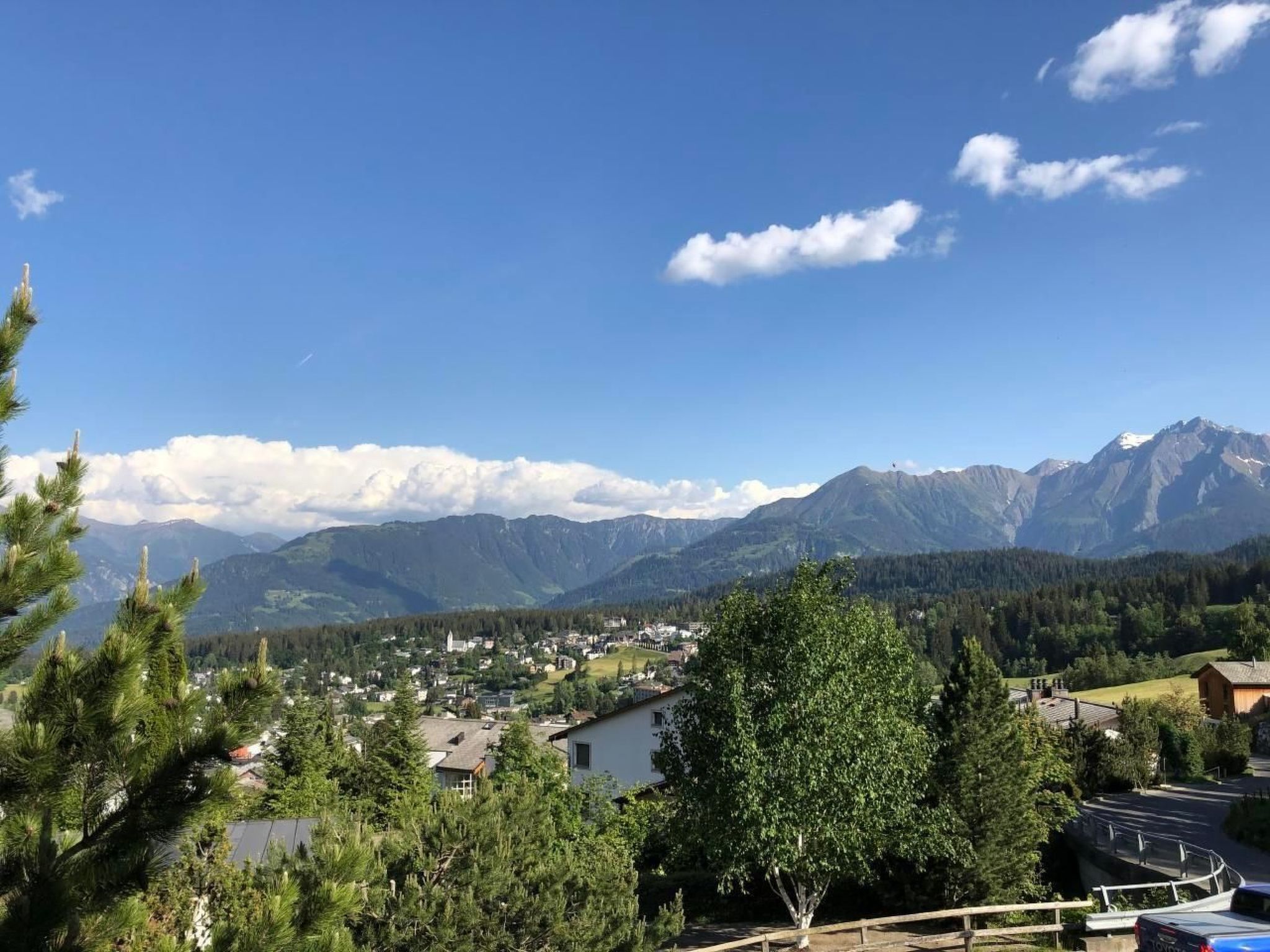 Un quartier résidentiel avec des maisons, une route et des montagnes en arrière-plan.