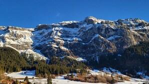 Paesaggio montuoso con cime innevate e cielo azzurro intenso.