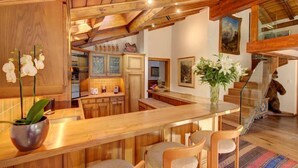 Een houten interieur met een keuken, een bar en een trap.