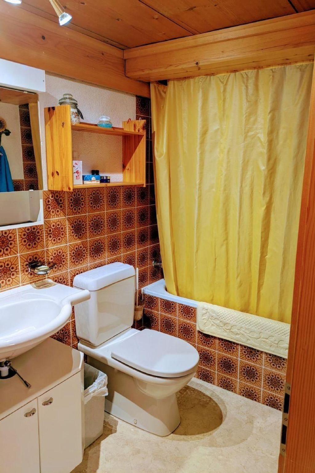 Et badeværelse med toilet, vask og bruseforhæng.