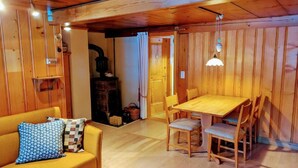 Un interior de madera acogedor con sofá, mesa de comedor y sillas.