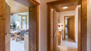 A wooden interior hallway with a dining area visible through an open door. - Appartement "Hochgefühl" by Interhome (Leutasch)