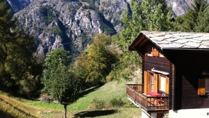Eine Berglodge mit Balkon und Blick auf zerklüftete Berge.
