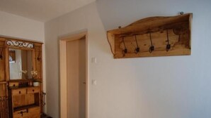 Un pasillo con un aparador de madera y un perchero en la pared.