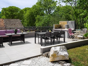 An outdoor patio area with a dining table, chairs, a sofa, and a grill station. - Gemütliches Ferienhaus Mia by Interhome (Dugopolje)