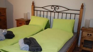 A double bed with a wooden headboard and two nightstands. - Feriendorf Uorsin Nr 8 by Interhome (Scuol)