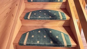 A wooden staircase with a handrail and carpeted steps. - Chalet Poiema by Interhome (Bellwald)