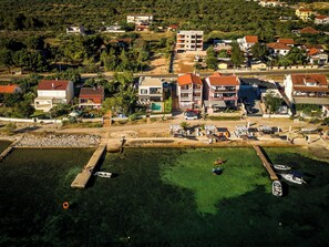 Ett flygbildsbild av en kuststad med byggnader, en småbåtshamn och båtar.