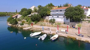 A marina with boats docked, a stone wall, and buildings with red roofs. - Ferienwohnung by Interhome (Novigrad (Zadar))