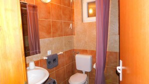 A bathroom with a toilet, sink, and shower. - Apartman Slavica by Interhome (Karin)