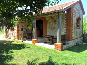 A rustic stone building with a tiled roof, a wooden bench, and a table outside. - Wohnung Delfin mit großer Terrasse - TA Leut Agency by Interhome (Privlaka)
