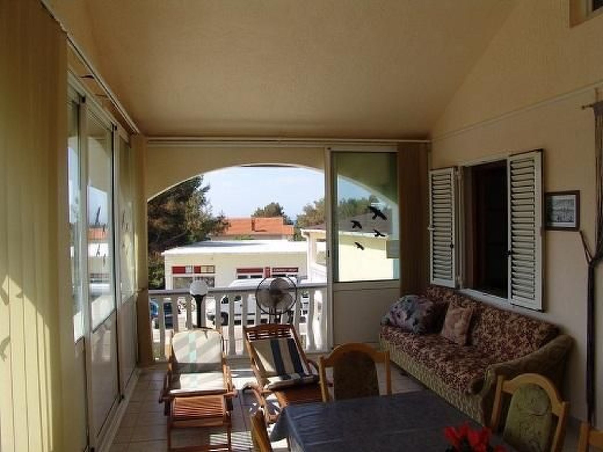 A balcony with a sofa, chairs, and a table.
