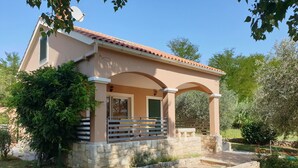 A two-story house with a covered porch, stone walls, and a paved driveway. - Am Fluss gelegenes Haus mit Galerieschlafplätzen by Interhome (Nin)