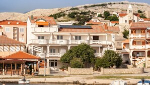 Un pueblo costero con edificios que tienen balcones y una iglesia con campanario.
