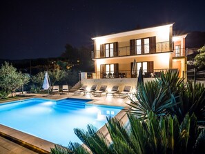 A two-story building with a swimming pool, outdoor seating, and a balcony. - Ferienvilla 'Villa Dalmatica' in Split by Interhome (Podstrana)