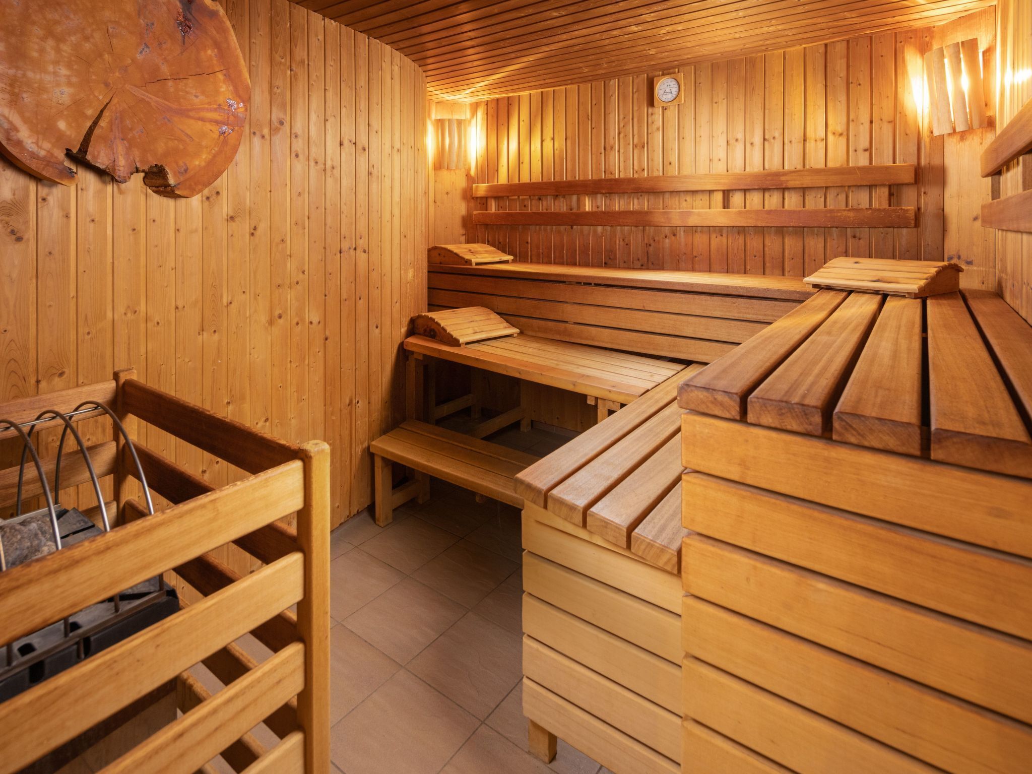 A sauna with wooden benches and benches, wooden walls, and a wooden floor.