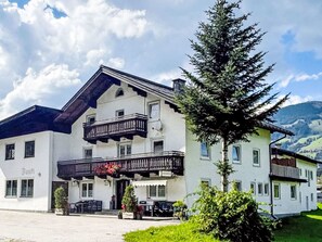 Un bâtiment à deux étages doté d’un balcon, d’une enseigne sur laquelle on peut lire le mot « Ban », et d’un grand arbre devant.