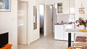 Eine moderne Wohnung mit Küche, Essbereich und einem Fernseher auf einem Holzboden.