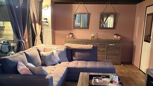 A cozy living room with a sectional sofa, a wooden coffee table, and a wooden floor. - Wellness-Ferienhaus für 5 Personen by Interhome (Stavenisse)