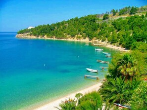 A coastal landscape with a clear blue sea, a sandy beach, and several boats anchored near the shore. - Villa Martina Matea große Villa mit beheiztem Pool by Interhome (Omiš/Lokva Rogoznica)