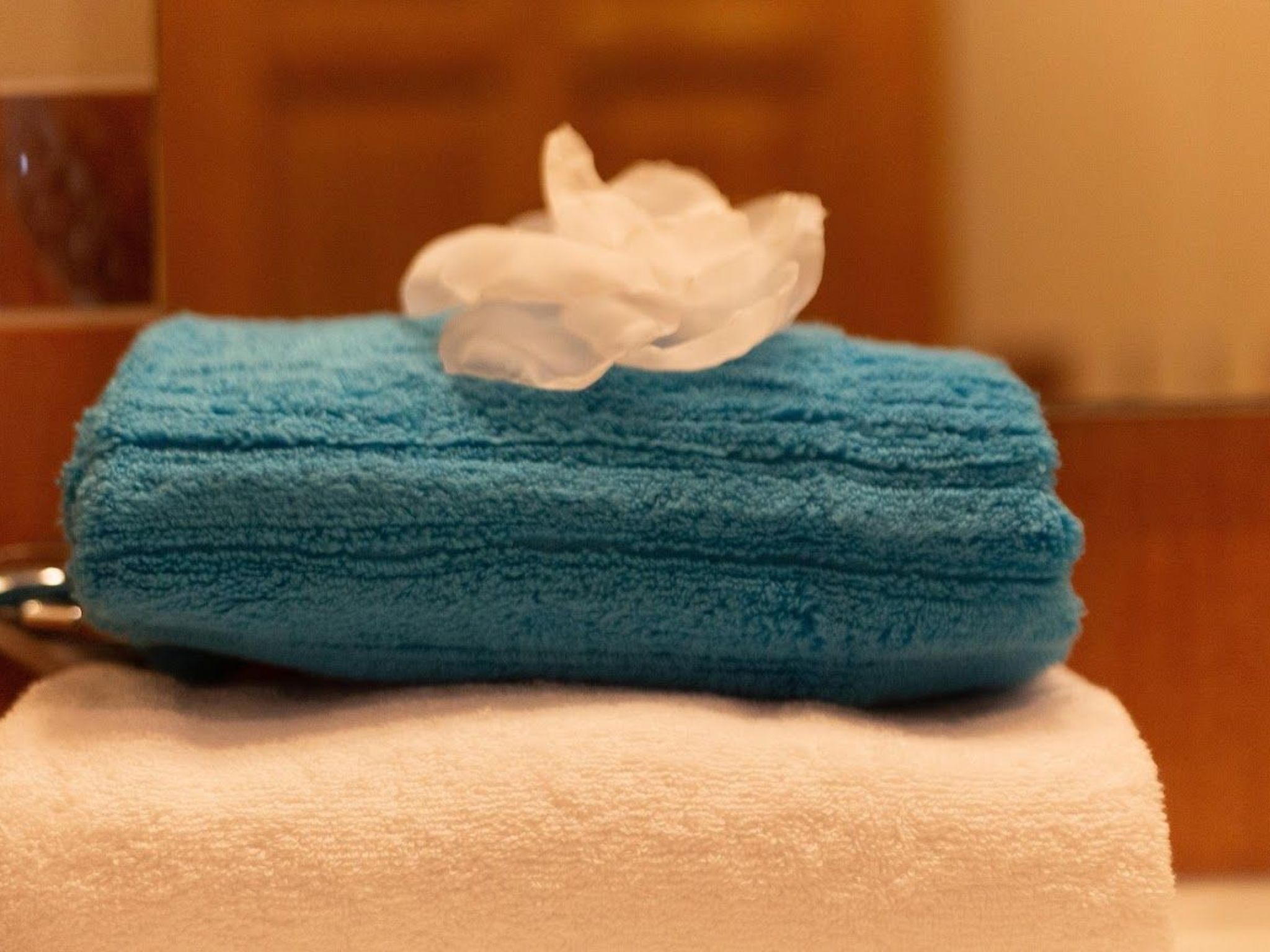 A blue towel with a white tissue on a white towel.