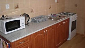 Una cocina con armarios de madera, microondas, hervidor, tostadora y estufa.