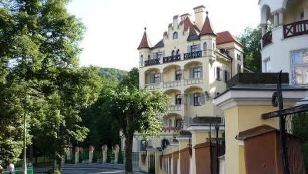 Un edificio de varios pisos con estilo arquitectónico clásico, que destaca por una torre imponente y múltiples balcones.
