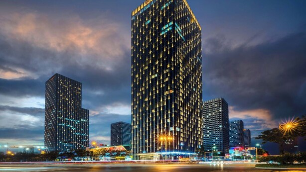 A high-rise building with a grid of windows and a prominent entrance at the base. - Taian Yuelan Hotel Wanda Plaza Taishan (Tai'an)