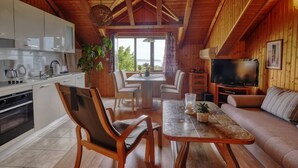 Un interior acogedor de cabaña con comedor, cocina y sala de estar.