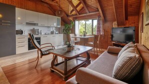 Interior acogedor de una cabaña con cocina, comedor y sala de estar.