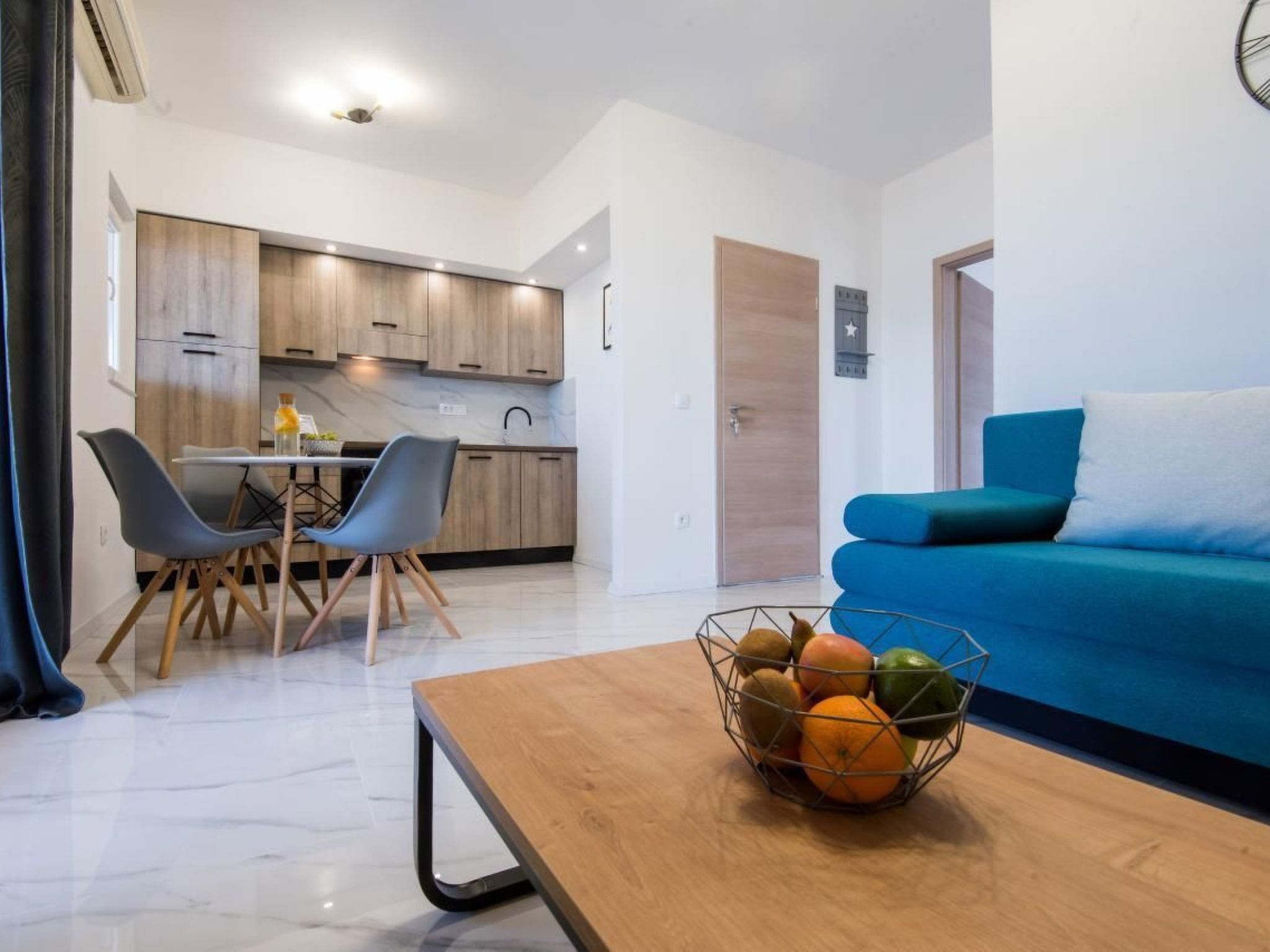 A modern apartment with a kitchen, dining area, and living room.