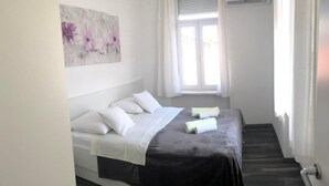A modern hotel room with a bed, a window, and a painting on the wall. - Apartment Sara by Interhome (Zadar)