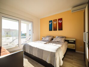 A bedroom with a bed, a window, and a wall-mounted air conditioner. - Apartment Sukosan by Interhome (Debeljak)