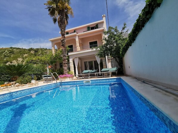 A two-story building with a swimming pool in the foreground. - mit Privatpool neben dem Strand by Interhome (Omiš)