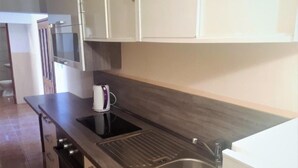 A kitchen with a stainless steel sink, a kettle, and a microwave. - für 6 Personen ca. 65 m² in Zubovici, Adriaküste Kroatien (Kroatische Inse by Interhome (Pag/Zubovići)