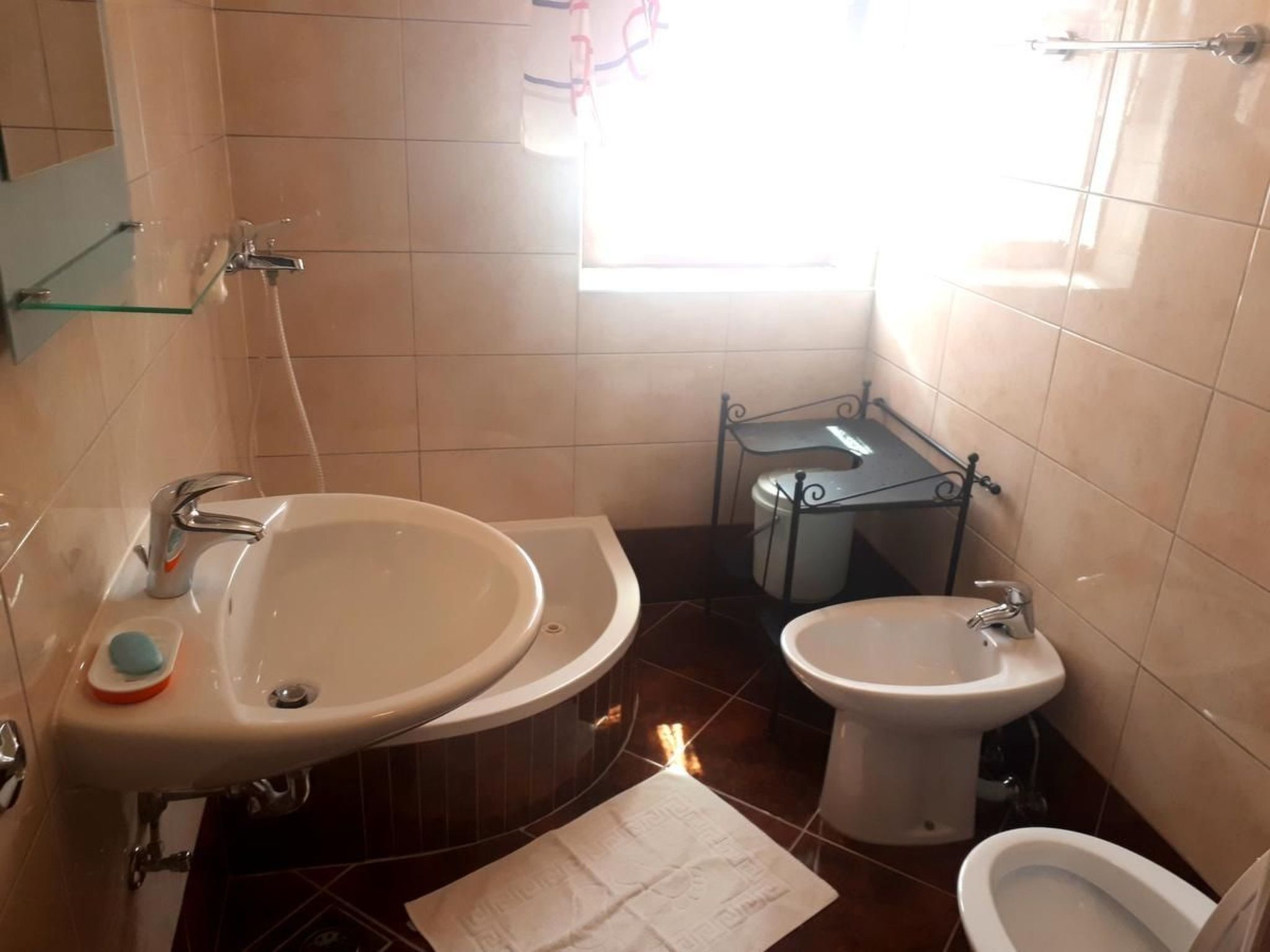 A bathroom with a sink, bidet, and toilet.