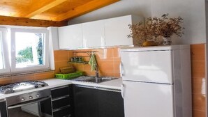 A kitchen with a stove, oven, sink, and white cabinets. - für 4 Personen  + 2 Kinder ca. 60 m² in Zubovici, Adriaküste Kroatien (Kro by Interhome (Pag/Zubovići)