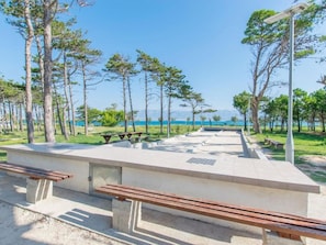 A park with benches and picnic tables, surrounded by trees and a view of the sea. - Wohnanlage Sunset Sabunike - TA Leut Agency by Interhome (Privlaka)
