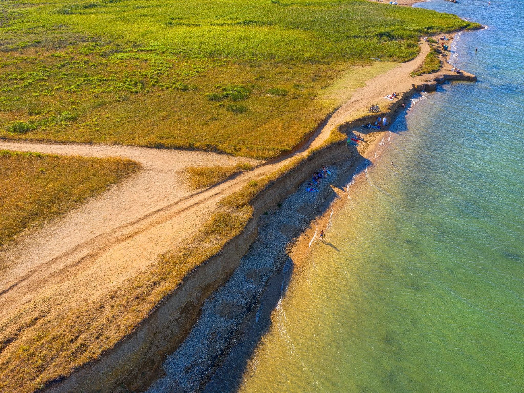 Vista aérea de una zona costera con playa de arena y agua cristalina.