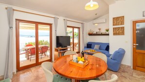 Ein Wohnzimmer mit einem Holzespeisetisch, einem blauen Sofa und einem Fernseher.