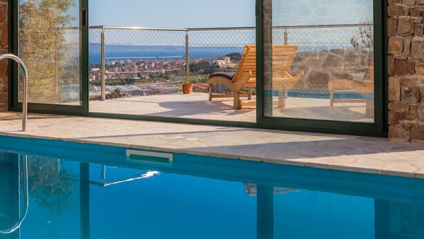 Ein Poolbereich mit Blick auf eine Stadt und eine Steinmauer.