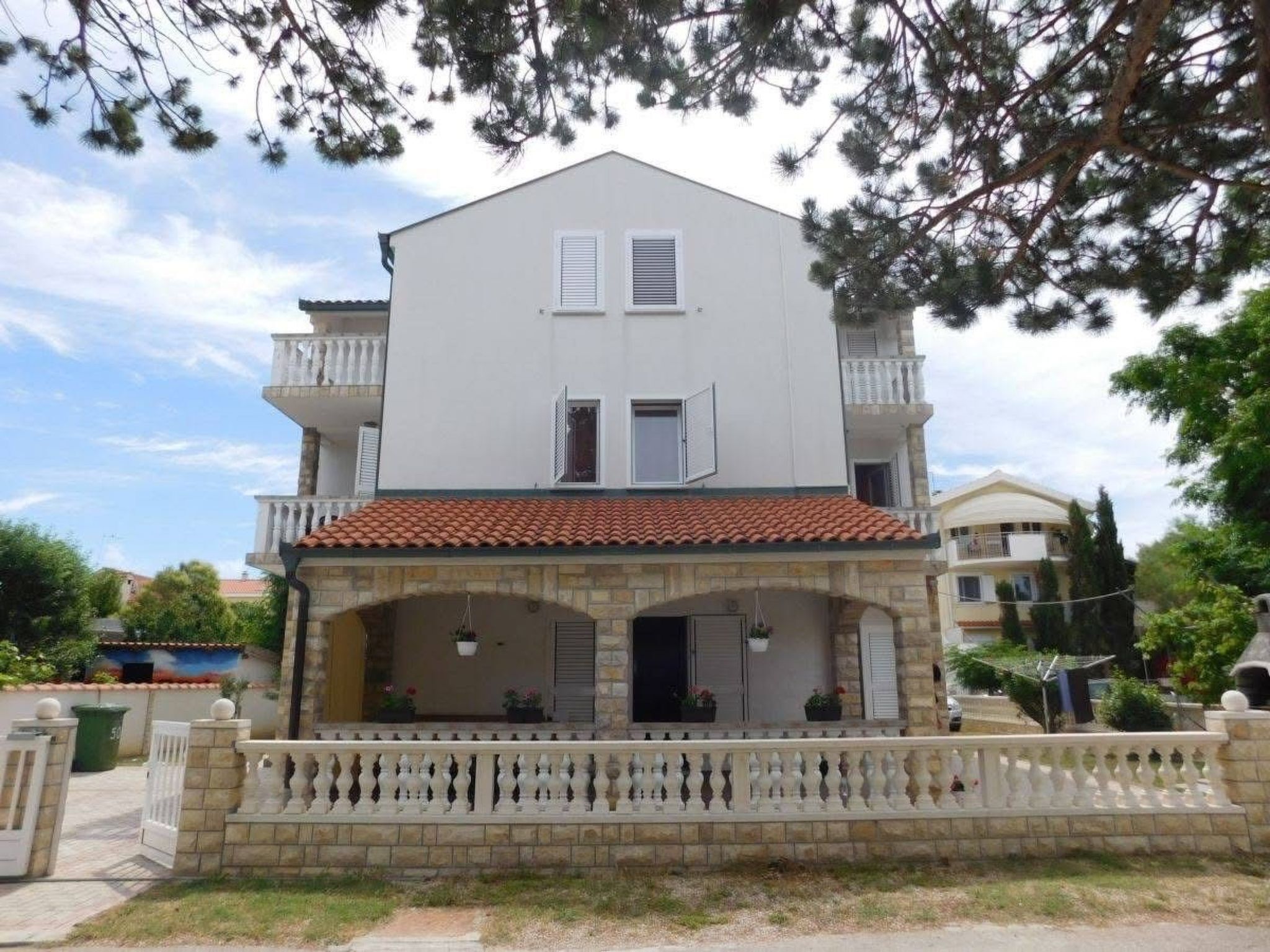 Un bâtiment à deux étages doté d’un balcon, d’un toit en tuiles et d’une façade en pierre.